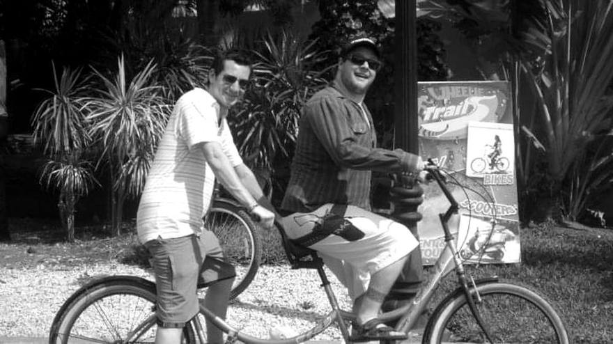 The two hosts on a tandem bicycle